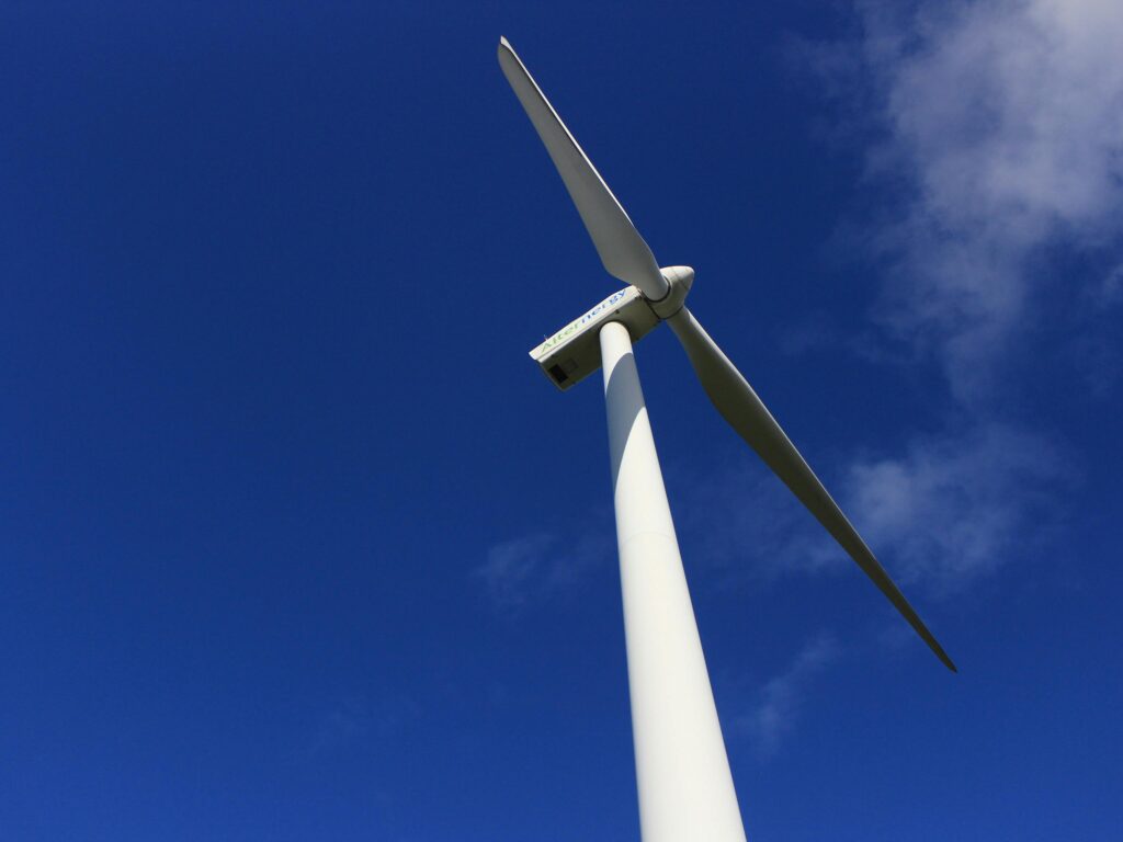 IEEE Young Engineers Conference A majestic wind turbine towering against a bright blue sky, showcasing renewable energy.