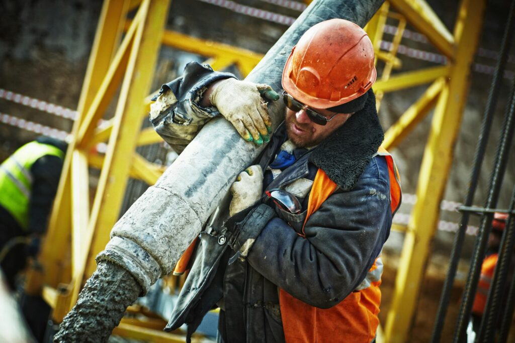 IEEE Young Engineers Conference Construction worker in safety gear handling equipment on an active site.